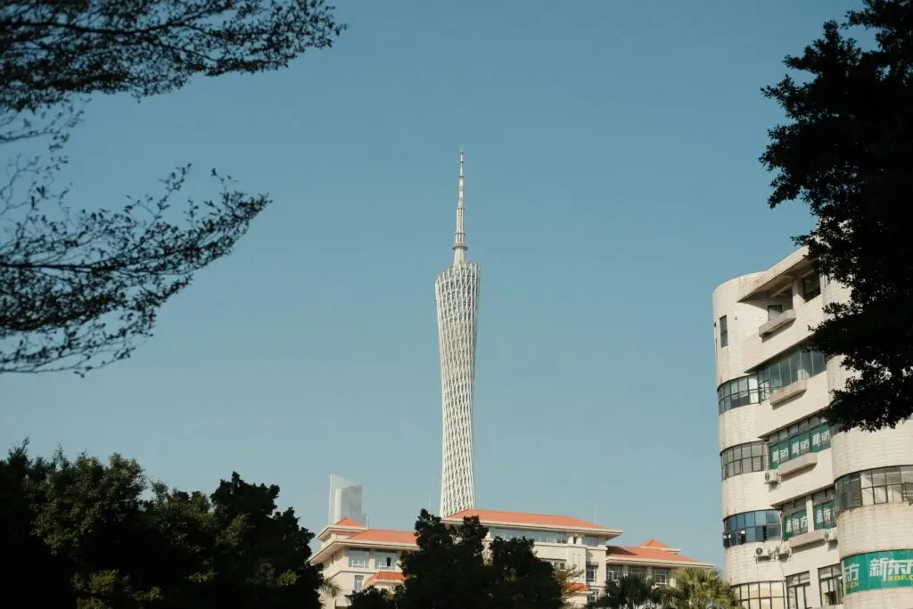 View of Guangzhou Tower surrounded by modern architecture under clear blue skies.